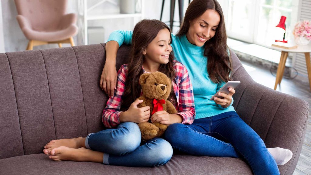 mom and daughter on couch looking at phone