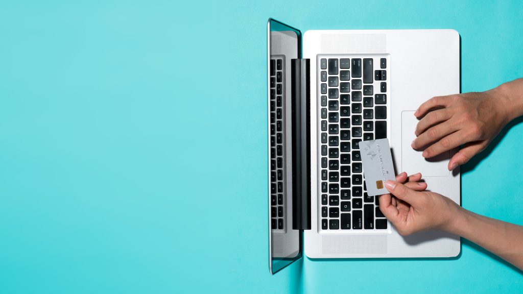 holding credit card on laptop