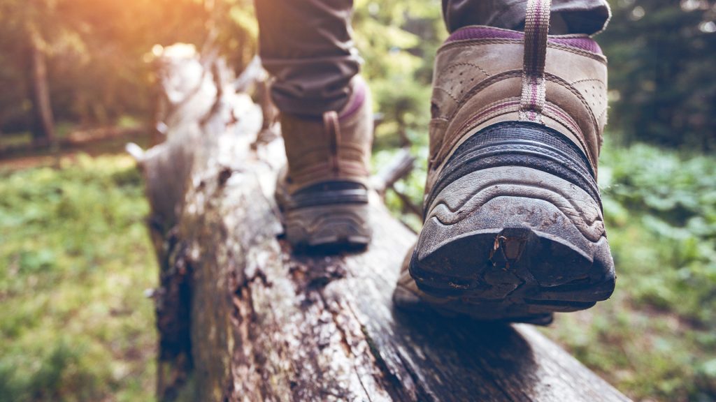 someone walking on log with boots