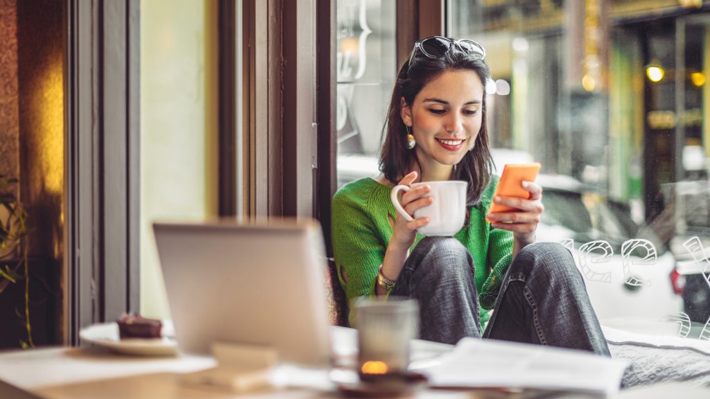 woman sitting with coffee on phone