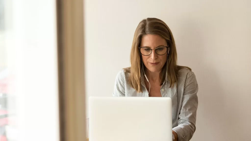 woman with glasses on laptop