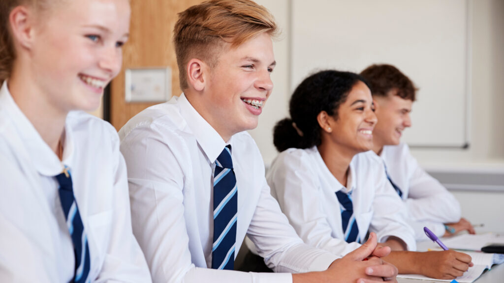 students with uniforms sitting at desk